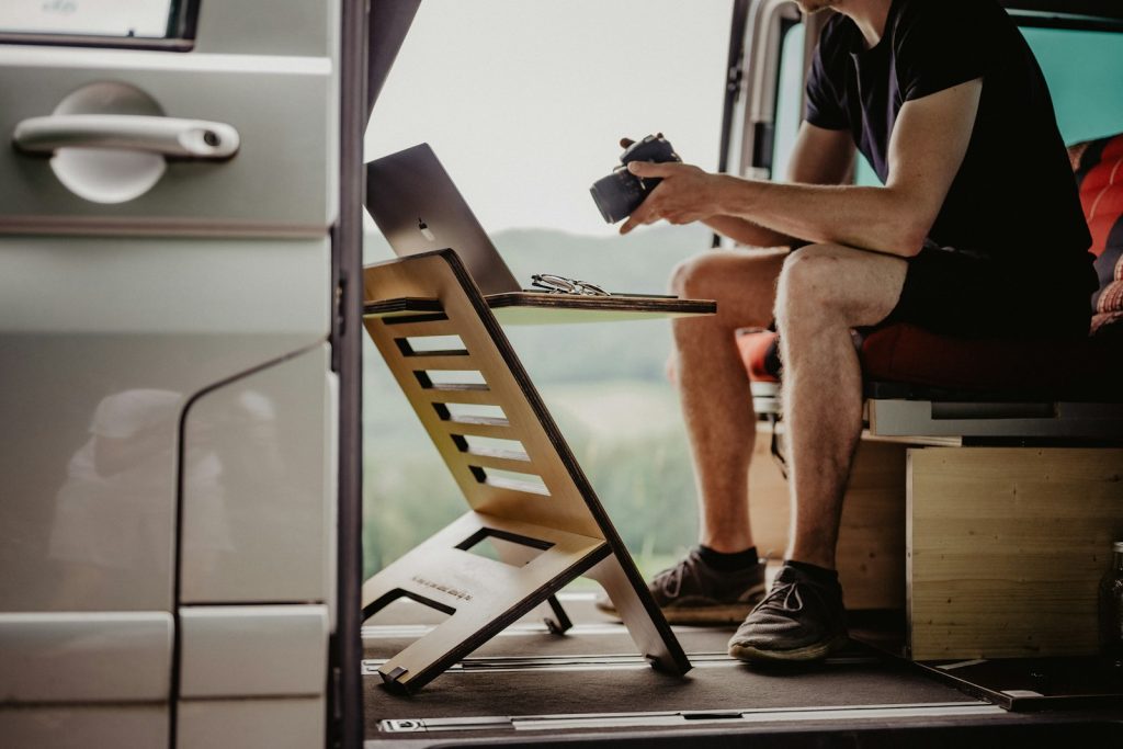 Ondernemer werkt op een laptop achter in zijn bus