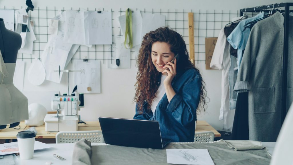 Eigenaar van een kleine zaak belt en werkt op een laptop