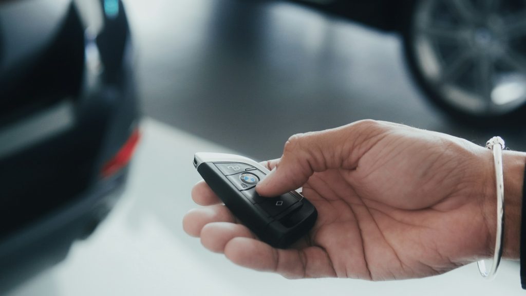 Autosleutel wordt overhandigd naast een geparkeerde auto